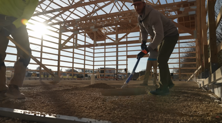 Workers leveling gravel layer in preparation of Heat Sheet Heavy Panel installation